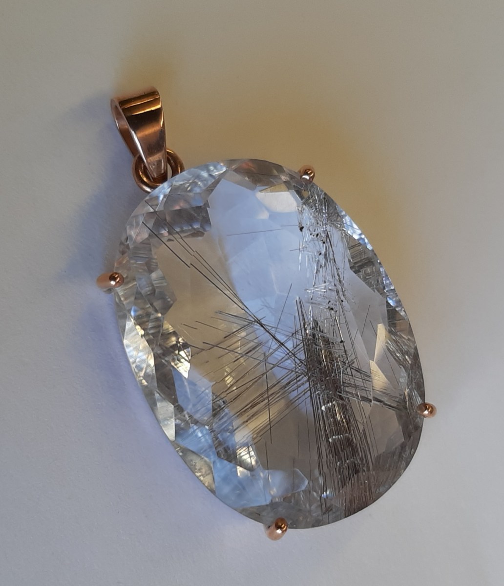 silver threads in the pendant set in rose gold.